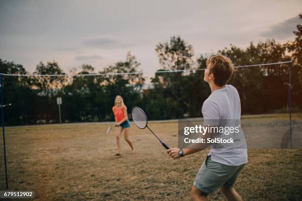 young couple playing badminton in the park - badminton stock pictures, royalty-free photos & images