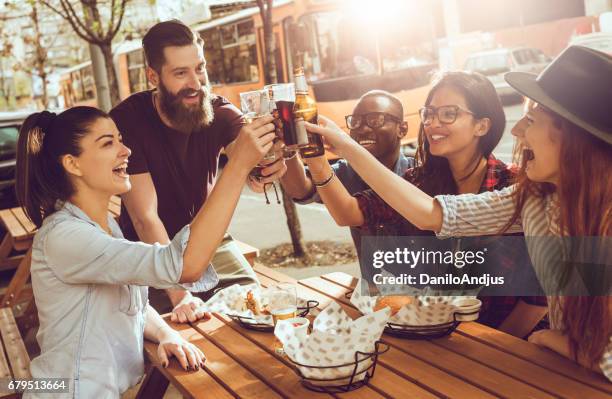 cheerful group of friends having fun and clinking their glasses - group of beautiful people stock pictures, royalty-free photos & images