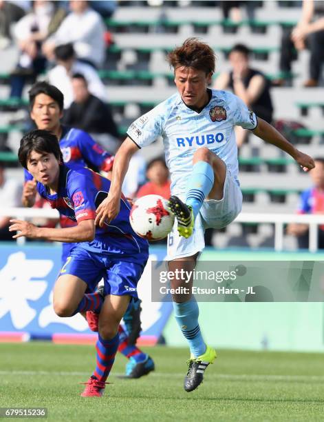 Keisuke Tanabe of FC Ryukyu controls the ball under pressure of Mao Kobayashi of FC Tokyo during the J.League J3 match between FC Tokyo U-23 and FC...