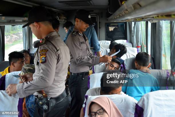 Police conduct a spot check at the exit access road of Pekanbaru city in Riau province on May 6 a day after more than 200 inmates broke out of the...