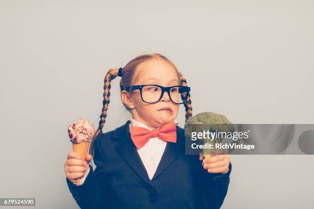 jonge vrouwelijke nerd houdt ijs en broccoli - kid eating ice cream stockfoto's en -beelden