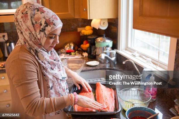 Amanda Saab, prepares the salmon before the dinner party. Saab, along with her husband Hussein Saab, co-hosted a "dinner with your Muslim neighbor"...