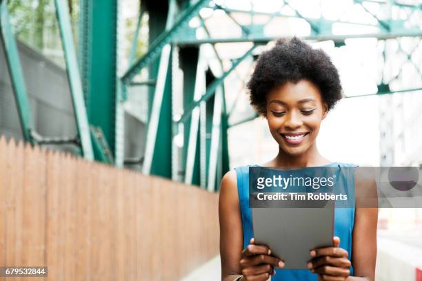 woman using tablet with iron grid bridge - business person on tablet stock pictures, royalty-free photos & images