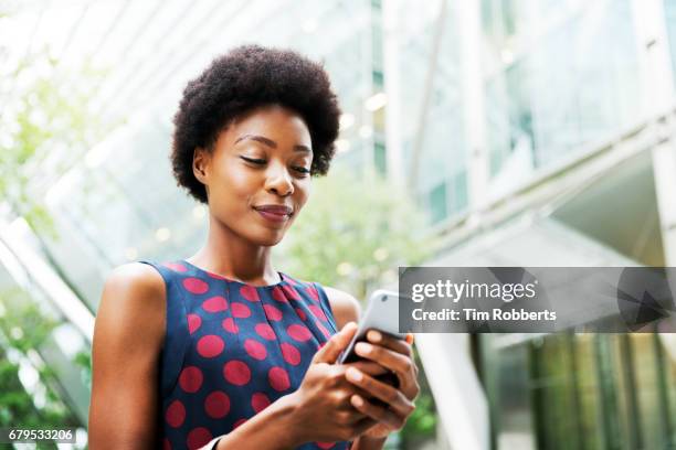 woman using smart phone - woman looking down smiling stock pictures, royalty-free photos & images