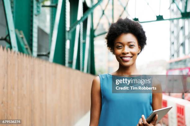 woman with tablet under iron grid bridge - businesswoman under stock-fotos und bilder