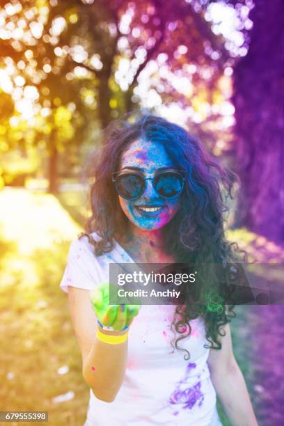 charmante teenager mit wunderschönen lächeln mit staub farbe in der hand. bunte mädchen feiern holi-fest. - hand smile painted stock-fotos und bilder