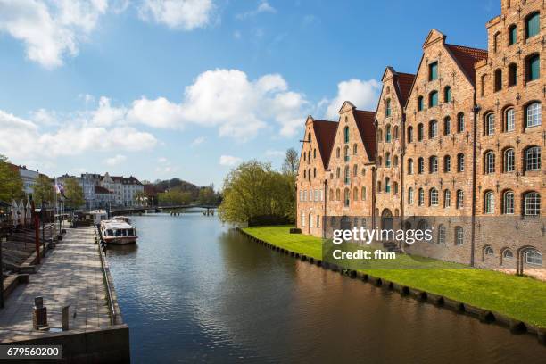 lübeck: historic salt store buildings with main promenade and sightseeing boat on the obertrave river (schleswig-holstein/ germany) - lübeck stock-fotos und bilder