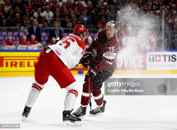 Andris Dzernis of Latvia challenges Oliver Lauridsen of Denmark for the puck during the 2017 IIHF Ice Hockey World Championship game between Latvia...