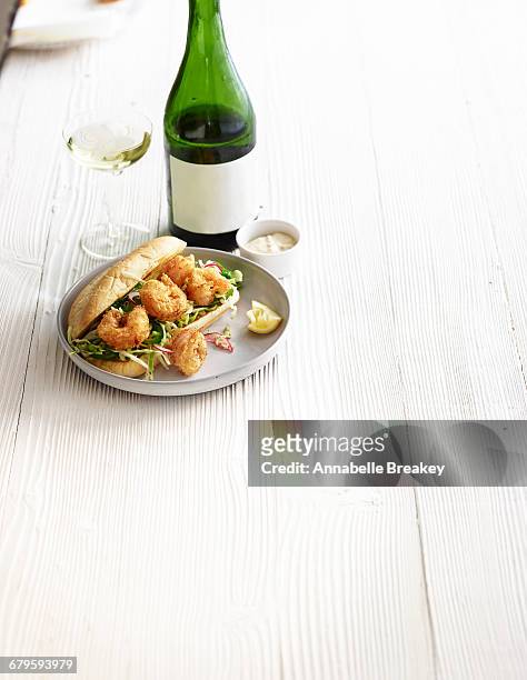 shrimp po boy and a bottle of white wine on white - annabelle(2014) ストックフォトと画像