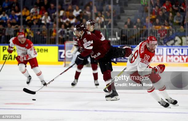 Kaspars Daugavins of Latvia challenges Emil Kristensen of Denmark for the puck during the 2017 IIHF Ice Hockey World Championship game between Latvia...