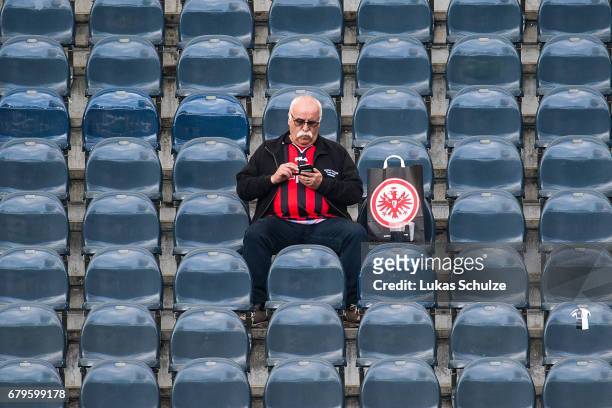 Fan of Frankfurt looks on his smartphone prior to the Bundesliga match between Eintracht Frankfurt and VfL Wolfsburg at Commerzbank-Arena on May 6,...