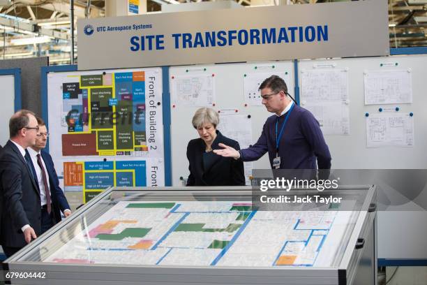 British Prime Minister Theresa May is shown a display as she tours the UTC Aerospace Systems factory during a campaign visit on May 6, 2017 in...