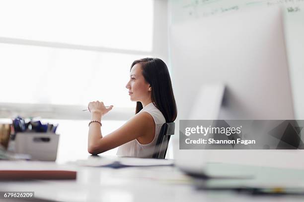 woman sitting in chair looking out office window - alternative view portraits stock-fotos und bilder