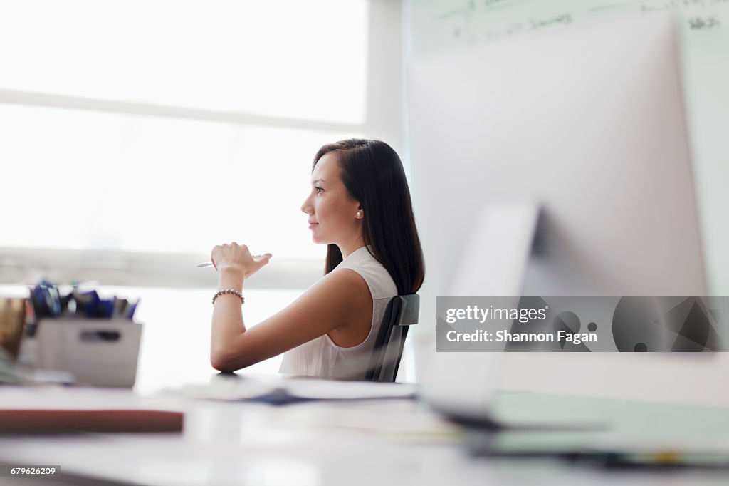 Woman sitting in chair looking out office window