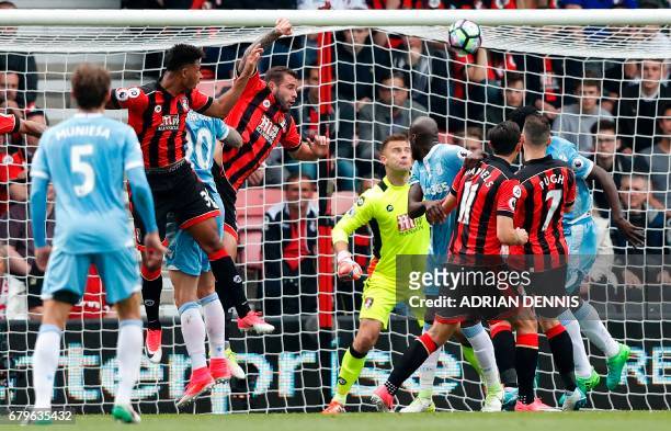 Bournemouth's French midfielder Lys Mousset watches the ball after heading to score an own goal during the English Premier League football match...