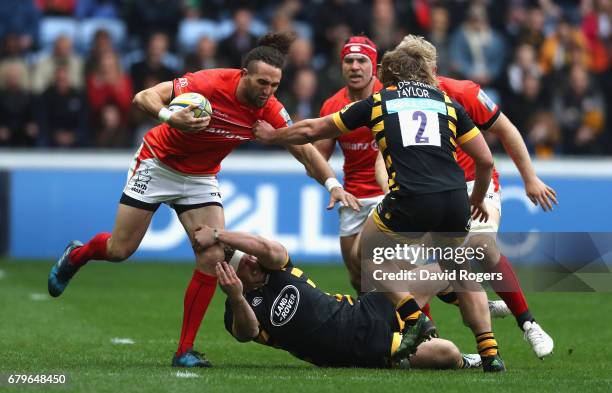 Mike Ellery of Saracens is tackled by Thomas Young and Tommy Taylor during the Aviva Premiership match between Wasps and Saracens at The Ricoh Arena...