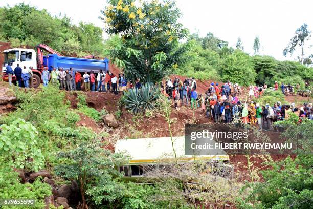 People look at the wreckage of a bus that had been transporting primary school pupils from Arusha to Karatu before plunging into a gorge, killing at...