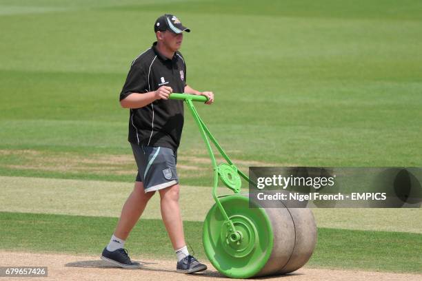 Groundstaff use a roller to tend to the wicket before the start of the days play