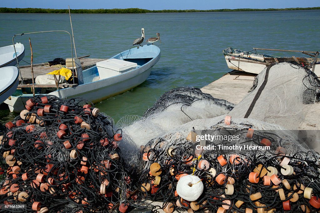 Fishing nets on pier; boats and ocean beyond