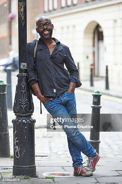 man leaning on lamp post - street light post stock pictures, royalty-free photos & images