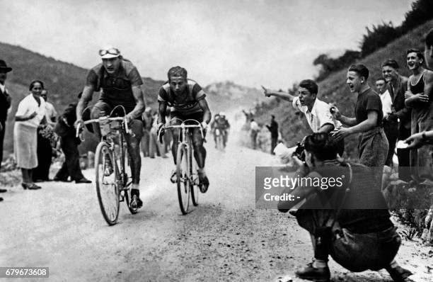 This file picture taken on August 24, 1938 shows Italy's riders Gino Bartali and Olimpio Bizzi , competing in the Giro d'Italia cycling race. / AFP...