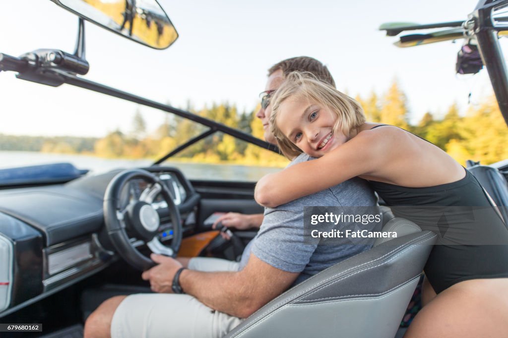 Cute daughter hugs her father on boat