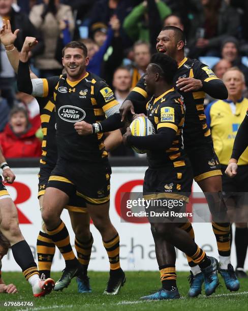 Christian Wade of Wasps celebrates with team mates Willie le Roux and Kurtley Beale after scoring a try during the Aviva Premiership match between...