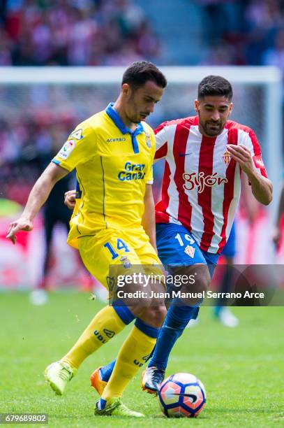 Hernan Santana of UD Las Palmas duels for the ball with Carlos Carmona of Real Sporting de Gijon during the La Liga match between Real Sporting de...