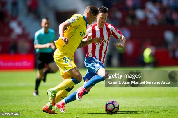 Erik Exposito of UD Las Palmas duels for the ball with Jorge Franco 'Burgui' of Real Sporting de Gijon during the La Liga match between Real Sporting...