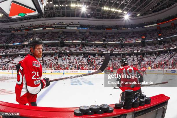 Chris Neil of the Ottawa Senators flips a pile of pucks onto the ice during warmup prior to Game Five of the Eastern Conference Second Round against...