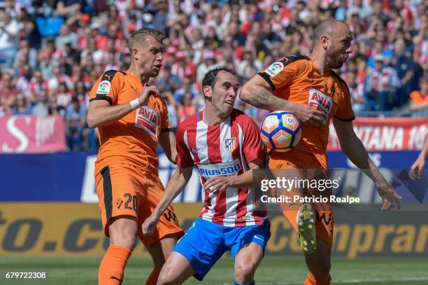 Diego Godin of Atletico de Madrid fights the ball with Florian Lejeune and Ivan Ramis of Eibar during a match between Club Atletico Madrid and SD...