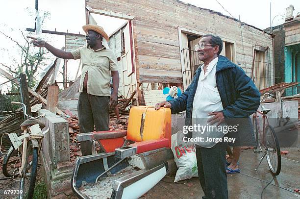 Neighbors survey damage to their property caused by Hurricane Michelle November 5, 2001 in Jaguey, Cuba.