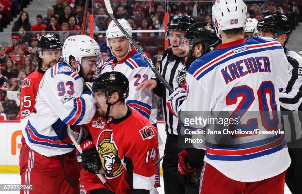 Mika Zibanejad of the New York Rangers shoves his arm into the face of Alexandre Burrows of the Ottawa Senators as teammates Nick Holden and Chris...