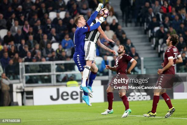 Joe Hart of Torino FC anticipates Mario Mandzukic of Juventus Fc during the Serie A football match between Juventus Fc and Torino Fc .