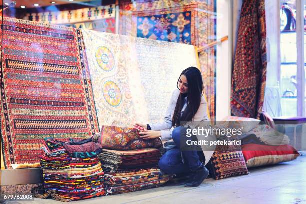 schöne junge frau kaufen teppiche im großen basar, istanbul, türkei - daily life in istanbul stock-fotos und bilder