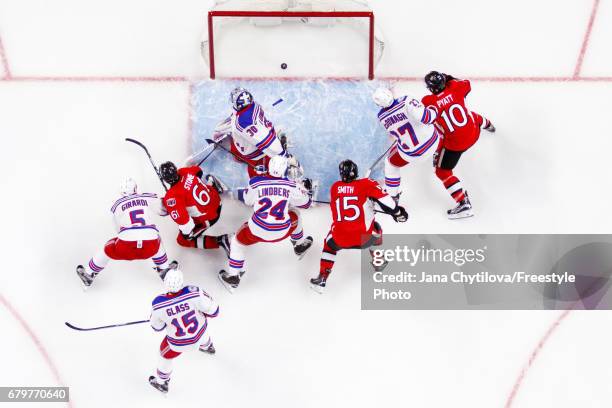 Mark Stone of the Ottawa Senators scores a first period goal against Henrik Lundqvist of the New York Rangers as Zack Smith and Tom Pyatt of the...