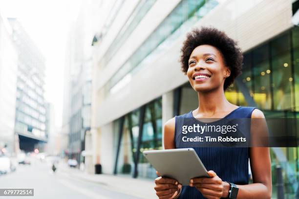 woman looking up with tablet - usare un tablet foto e immagini stock