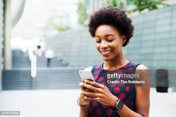 woman using smart phone - donna sorride cellulare foto e immagini stock
