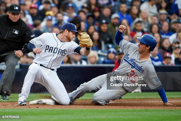 Cody Bellinger of the Los Angeles Dodgers steals third base ahead of the tag of Cory Spangenberg of the San Diego Padres during the fourth inning of...