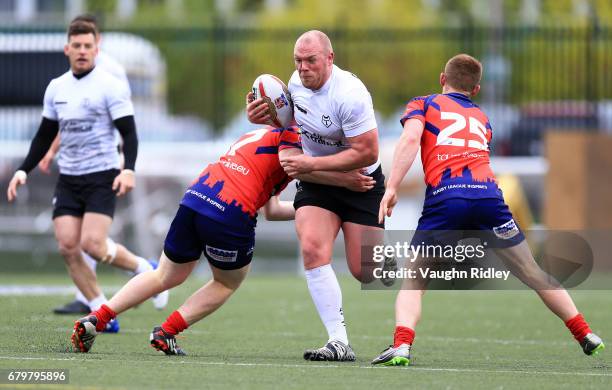 Steve Crossley of Toronto Wolfpack is tackled by Harrison Brough and Brad Moules of Oxford RLFC during the second half of a Kingstone Press League 1...