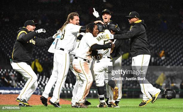 Josh Harrison of the Pittsburgh Pirates is mobbed by teammates after hitting a walk off single giving the Pittsburgh Pirates a 2-1 win over the...