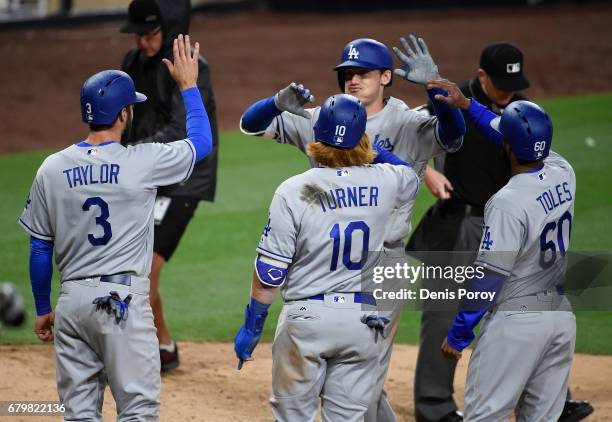 Cody Bellinger of the Los Angeles Dodgers, is congratulated by Chris Taylor, Justin Turner, and Andrew Toles after hitting a grand slam during the...