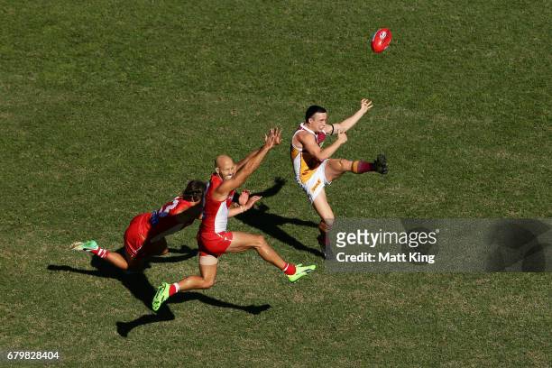 Lewis Taylor of the Lions takes a kick at goal as Jarrad McVeigh of the Swans defends during the round seven AFL match between the Sydney Swans and...