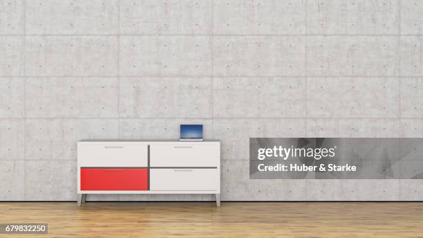 sideboard with laptop in front of concrete wall - hausdekor stockfoto's en -beelden