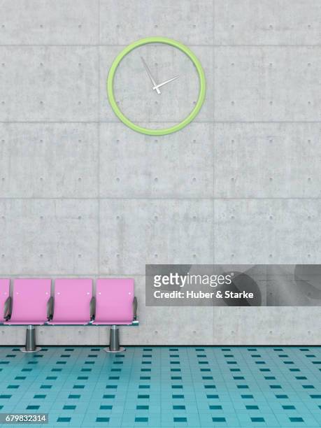 row of seats in front of concrete wall - abflugbereich stockfoto's en -beelden