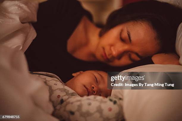 pretty mom sleeping soundly with baby at night - asian sleeping stock pictures, royalty-free photos & images
