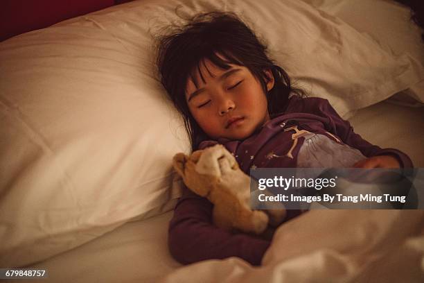 lovely little girl sleeping soundly on the bed - girl in her bed stockfoto's en -beelden