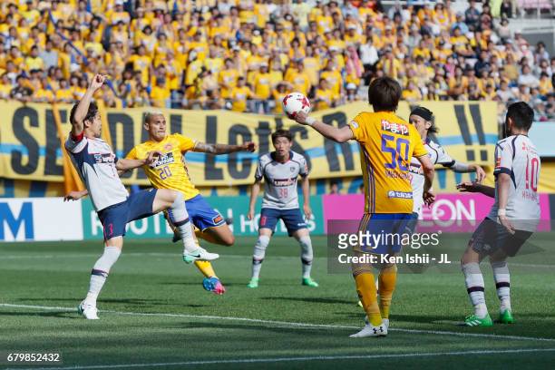Crislan of Vegalta Sendai shoots at goal while Masato Morishige of FC Tokyo tries to block during the J.League J1 match between Vegalta Sendai and FC...