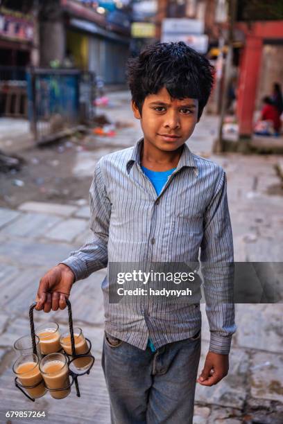 indiase jongetje verkopen chai op straten van kathmandu, nepal - child labor stockfoto's en -beelden