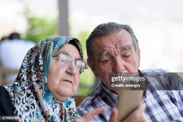 senior couple using mobile phone - old arab man stock pictures, royalty-free photos & images